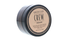 Hands applying American Crew Pomade for precise slick-back styling.