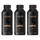 Anomaly clarifying shampoo bottle pour showing charcoal cleanse for buildup control