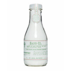 Barr-Co fir grapefruit bath salts jar shown in glass for relaxing soaks.