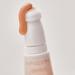 Catrice bottle featuring built-in sponge applicator for precise on-the-go touch-ups.