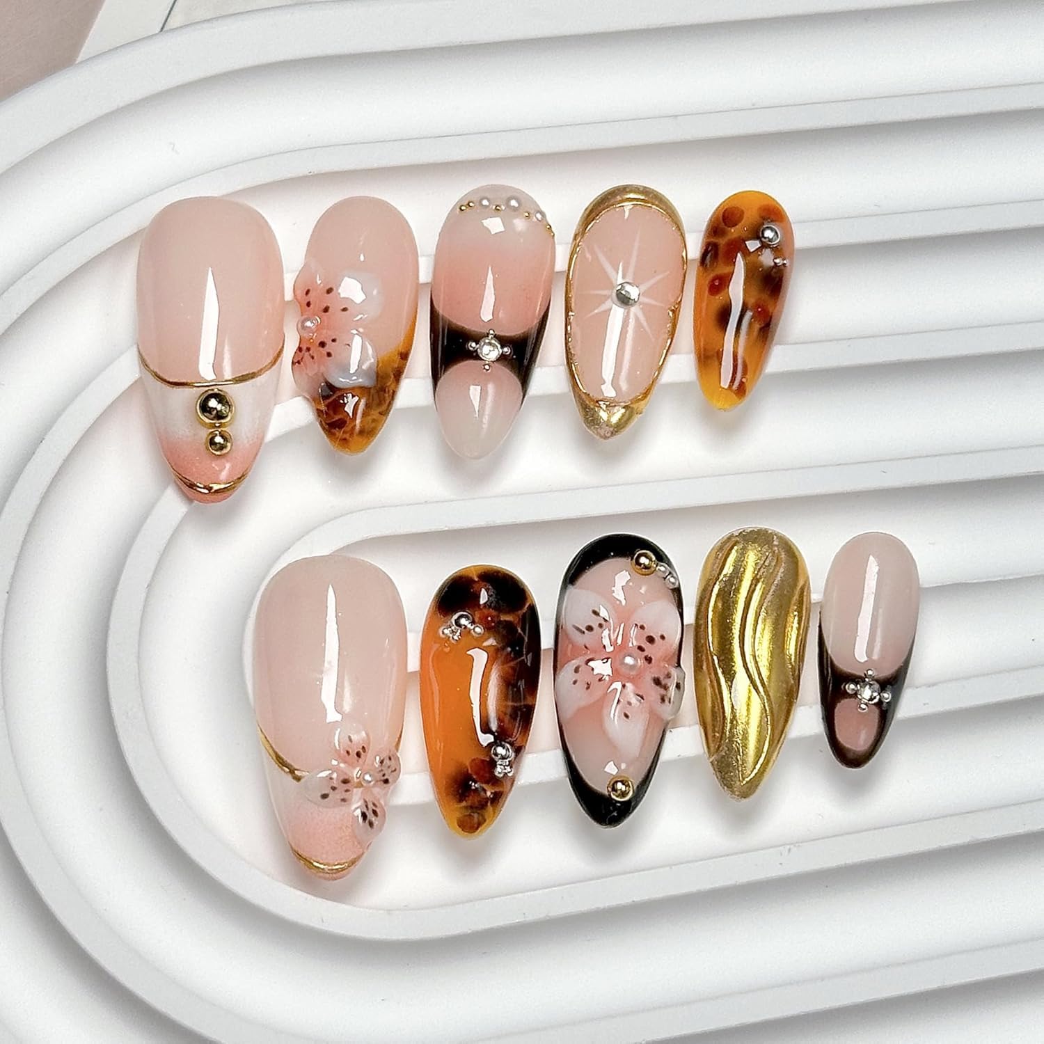 CTTHNBD medium almond nails with brown gold flower design for a stylish everyday look.