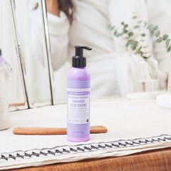Hands applying Dr. Bronner's Hair Creme for light hold and silky feel.