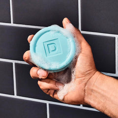 Duke Cannon puck soap close-up texture showing triple-milled durability.
