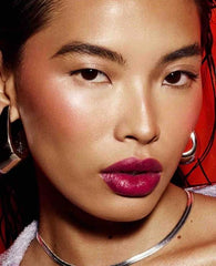 Fenty Beauty Poutsicle swatch reveals Fuchsia Wife sheer tint and shine.