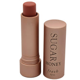 Fresh Sugar Honey Tinted Lip Treatment SPF 15 packaging emphasizing sleek design and moisture protection.