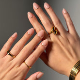 Glamnetic Goals nude nails with gold reverse French tip on hand showing long-lasting salon-style wear
