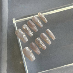 Long ballerina GLORS nails catching light with metallic gold design