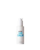 Hairstory Hair Balm bottle close-up highlights glossy moisture for smooth, hydrated hair.