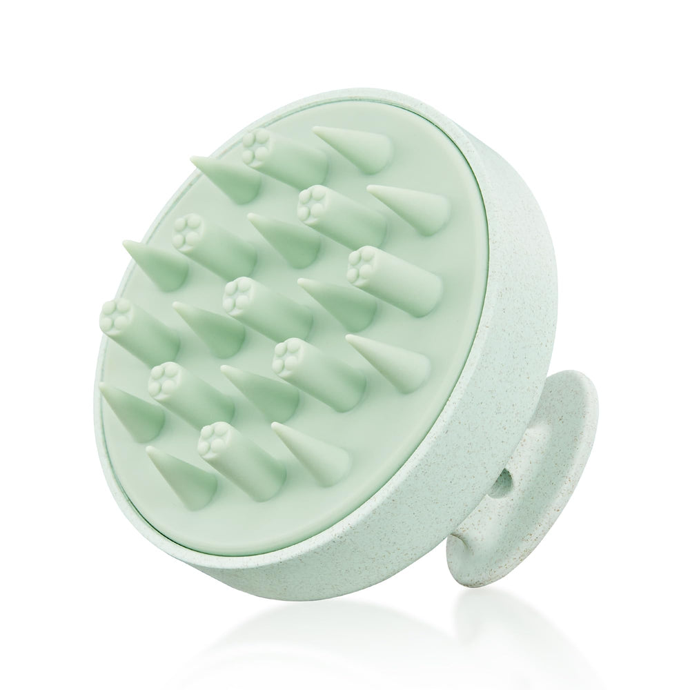 HEETA scalp massager in hand with eco-friendly wheat straw design and soft silicone bristles for gentle cleansing.