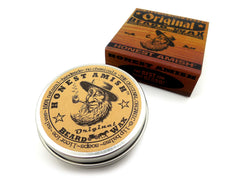 Hands applying Honest Amish Original Beard Wax to shape and tame hairs