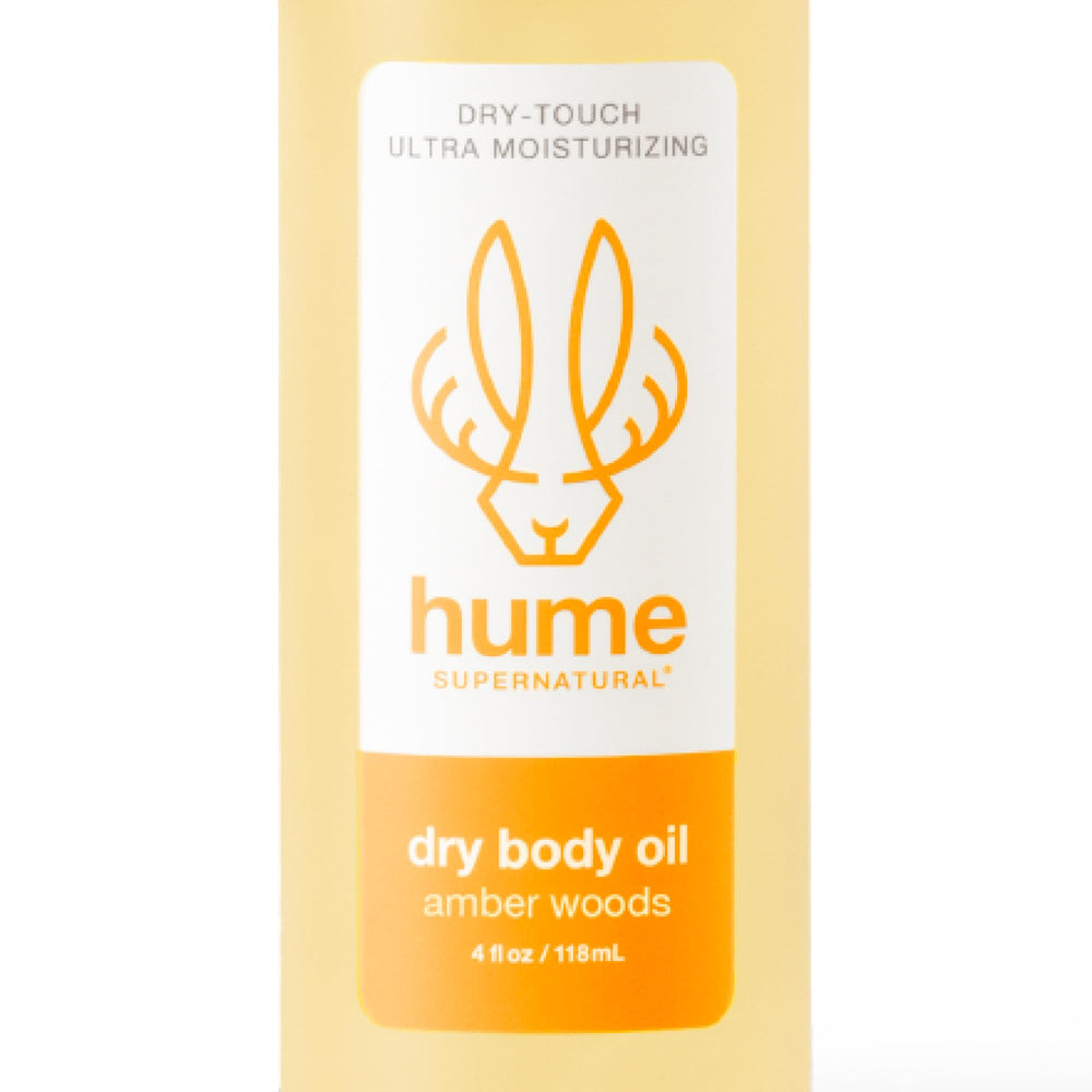 HUME SUPERNATURAL Dry Body Oil Spray bottle with Amber Woods scent for deep hydration.