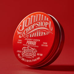 Johnny's Chop Shop pomade label close-up highlights high-shine formula for smooth style.