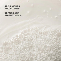 Josie Maran Argan Moisture Plump Shampoo pour into hand shows creamy lather forming.