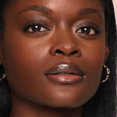 Jouer Lip Topper can be applied over lipstick for a customizable glow.