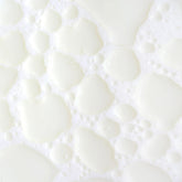 KORA Organics Milky Mushroom Oil Cleanser being shaken to activate creamy milk texture.