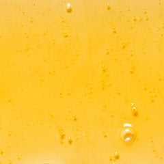 KORA Organics Noni Glow Body Oil application on hand for smooth, quick absorption.