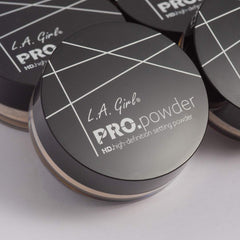 Hands applying L.A. Girl BB Pro Powder translucent with brush