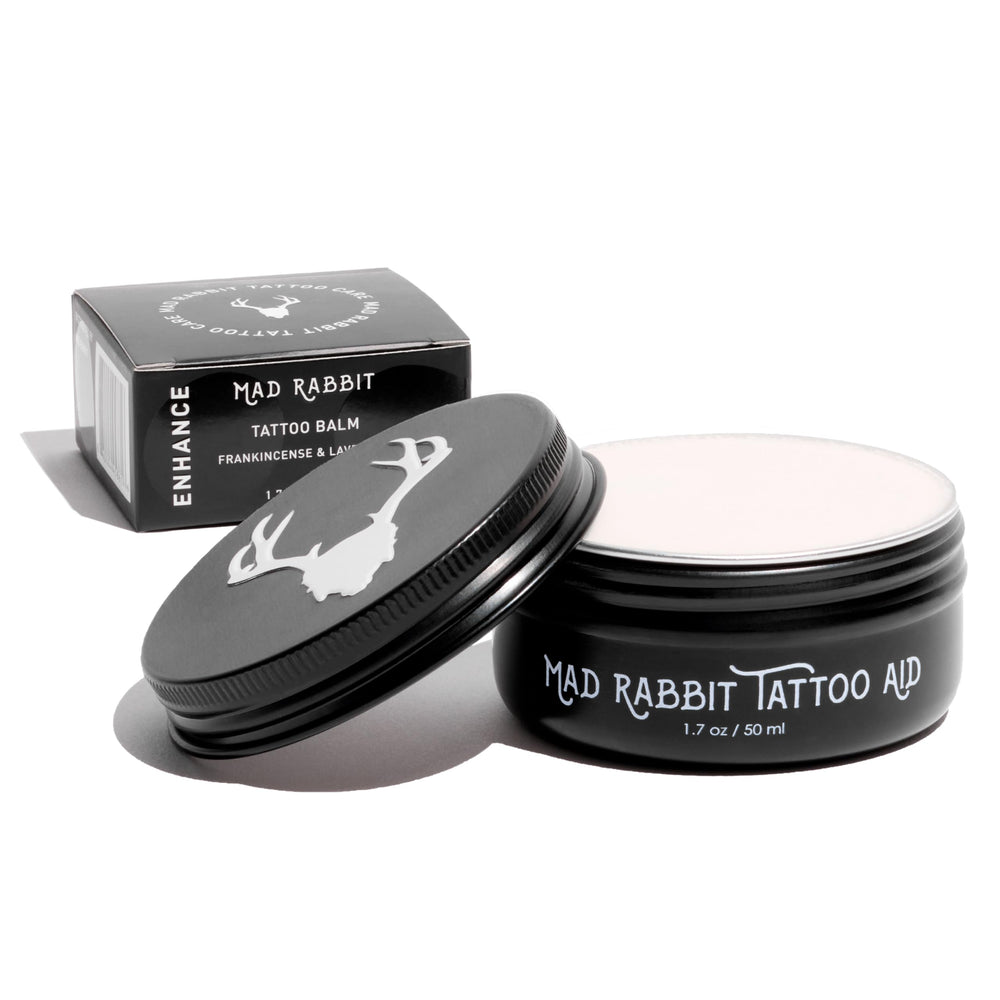 Mad Rabbit Tattoo Balm bottle applying barrier protection for vibrant ink.