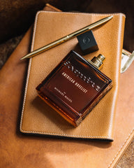 Michael Malul American Novelist Esquire base notes close-up highlighting woody warmth.