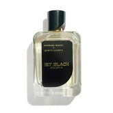 Michael Malul Jet Black Enigma bottle on a dark bar counter, commanding attention.