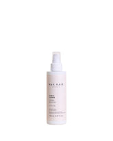 NAK Hair Curls Creme bottle close-up highlighting frizz-taming action