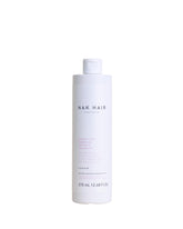 NAK Hair Structure Complex Shampoo bottle highlighting strength and hydration for damaged hair.