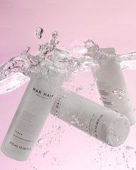 NAK Hair Structure Complex Shampoo pour showing smooth cleansing and effortless styling.