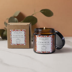 Natural Amor pumpkin-candle closeup emits cozy aroma for festive ambiance.