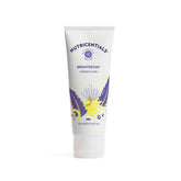 Nu Skin Brighter Day Exfoliant Scrub with pomegranate enzymes on a spa surface for a gentle glow.
