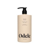Odele Volumizing Shampoo bottle on a vanity, for lightweight cleansing and shine.
