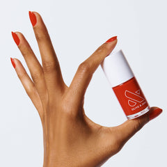 Olive & June long-lasting nail polish bottle pour shows rich cherry-red color for a salon-quality mani.