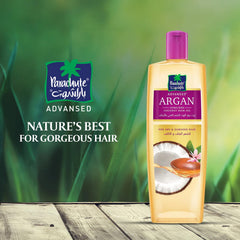 Parachute Advansed Argan Coconut Oil on hair strands for smoothness.