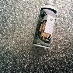 R+Co Moon Landing spray on hair for added shine and moisture.