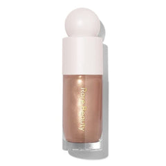 Rare Beauty Positive Light Luminizer Transcend bottle close-up showing luminous glow for instant radiance