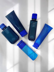 R+Co BLEU bottle under running water, illustrating gentle cleansing.