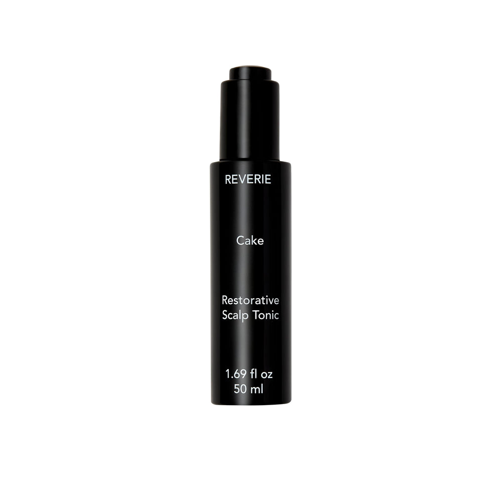 REVERIE Cake Restorative Scalp Tonic bottle pour showing soothing hydration for dry scalps