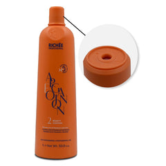 Hands applying Richée Argan Ojon oil through hair lengths and ends.