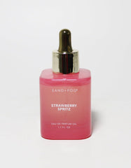 Sand + Fog Strawberry Spritz bottle on a clean surface, showcasing a vibrant, long-lasting fragrance.