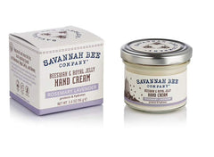 Savannah Bee Company Beeswax Hand Cream on a glossy surface shows smooth skin.
