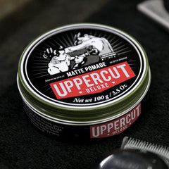 Hands applying Uppercut Deluxe Matte Pomade for textured hold