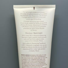 Close-up of GRO+ conditioner being applied to hair during application.