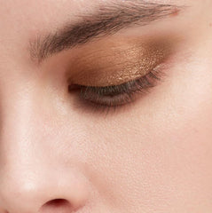 Victoria Beckham EyeWear Longwear Eyeshadow Stick Caramel swatch on arm for day-to-night versatility.