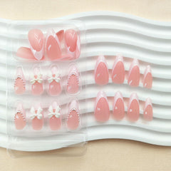 Xenophoer nails featuring white pearls and bow design for elegant embellishment.
