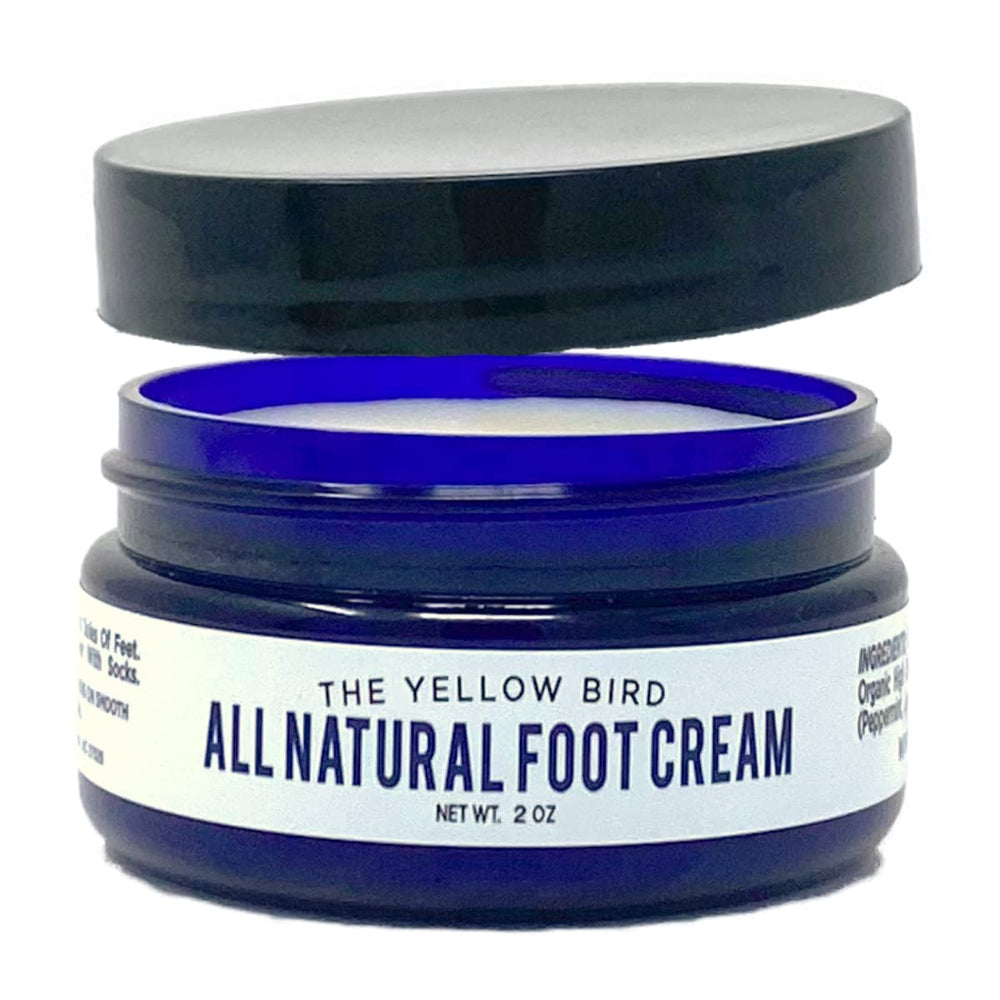 The Yellow Bird foot cream with tea tree oil in a jar delivers hydrating care.