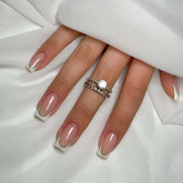 YIYILEIC French medium press-on nails in nude gloss with white border for elegant everyday wear.