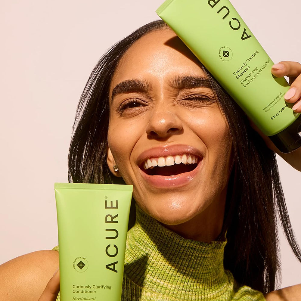 Applying Acure conditioner on wet hair from mid-length to ends.