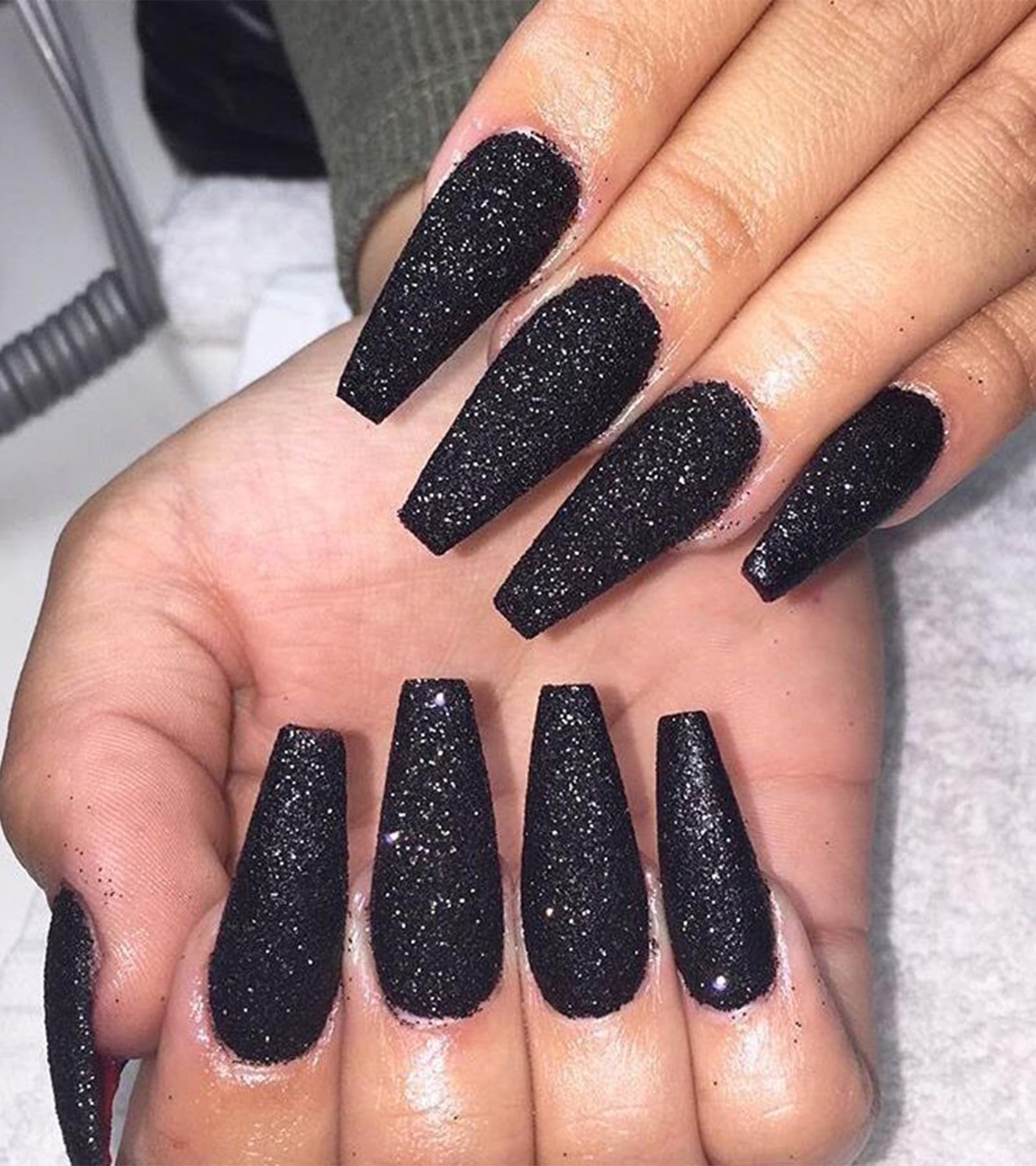 Aegenacess black coffin glitter nails for a salon-style look at home.
