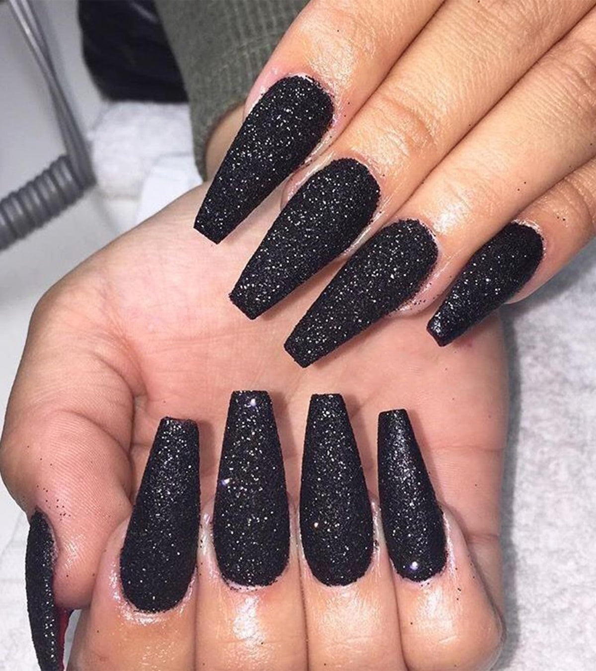 Aegenacess black coffin glitter nails for a salon-style look at home.