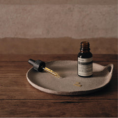 Drops dispense from Aesop Exalted Eye Serum onto the skin