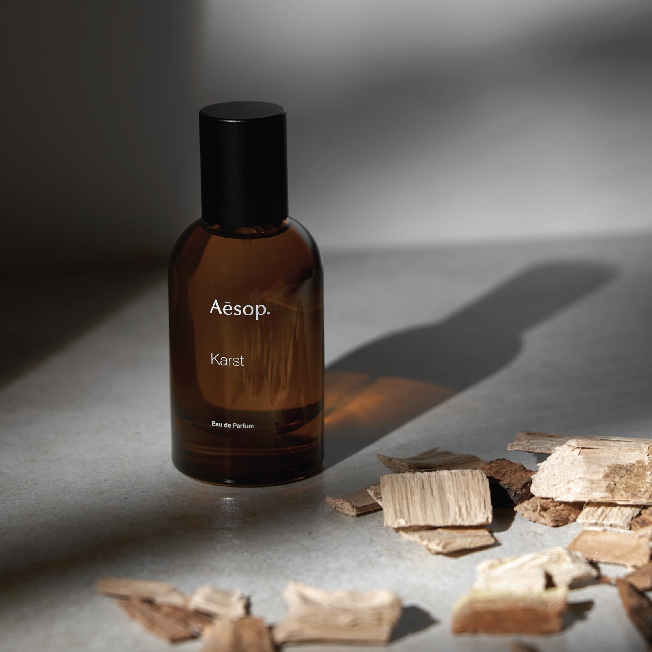 Aesop Karst bottle on wood background complements earthy sandalwood notes